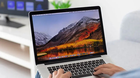 Customer reviewing MacBook Pro features before purchase at PayMore Seekonk